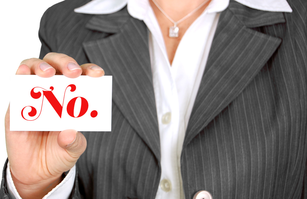 lady holding business card that reads "no"